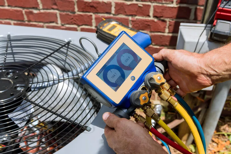 Technician checking refrigerant levels on residential AC unit