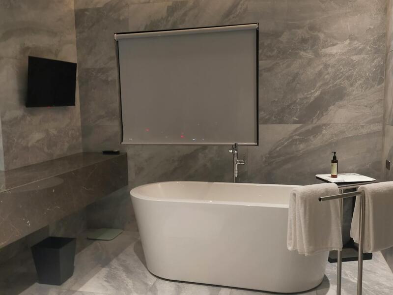 Freestanding soaking tub with marble walls, Carrboro spa bathroom by Ridgeway